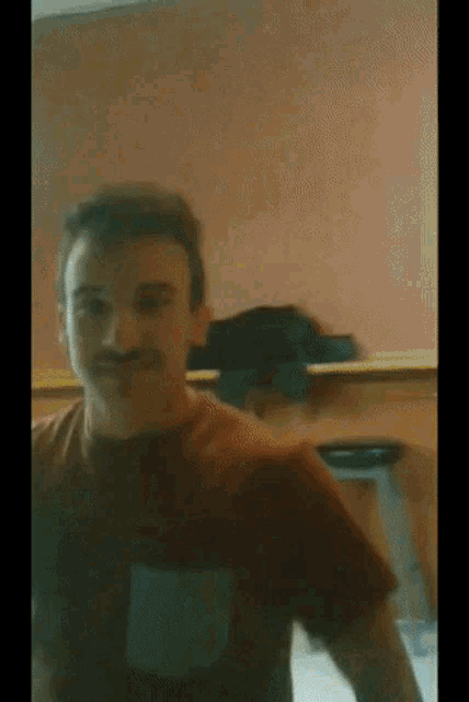 a man with a mustache is standing in front of a desk