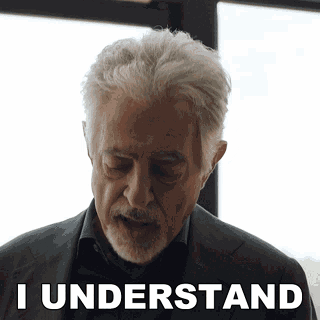 a man with gray hair and a beard says " i understand " in white letters