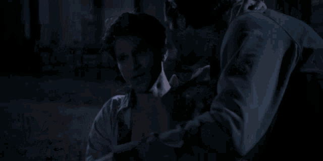 a man in a white shirt is being held by another man in a blue shirt