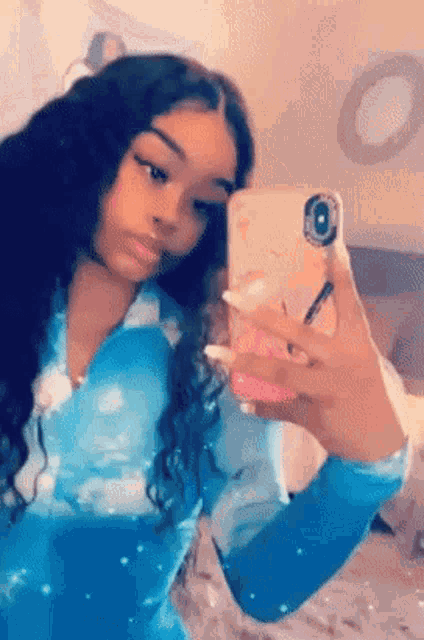 a girl is taking a selfie with her phone in her hand .