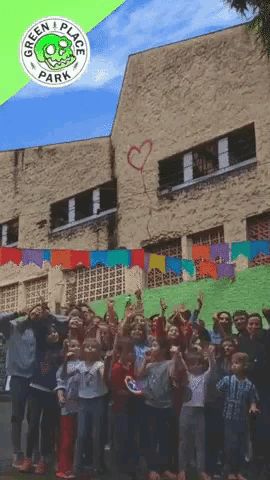 a group of people standing in front of a building that says green place park on it