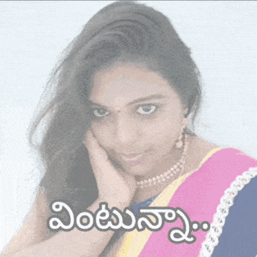 a woman in a pink and yellow striped saree with a hand on her face and a foreign language behind her