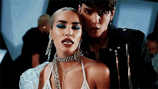 a woman wearing a choker is standing next to a man in a leather jacket