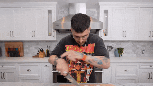 a man in a black t-shirt that says thrasher is preparing food
