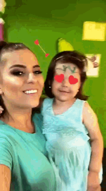 a woman holds a little girl with hearts on her eyes