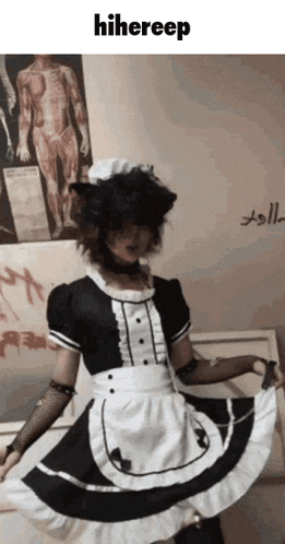 a person in a maid costume is dancing in front of a wall with a picture of a body on it