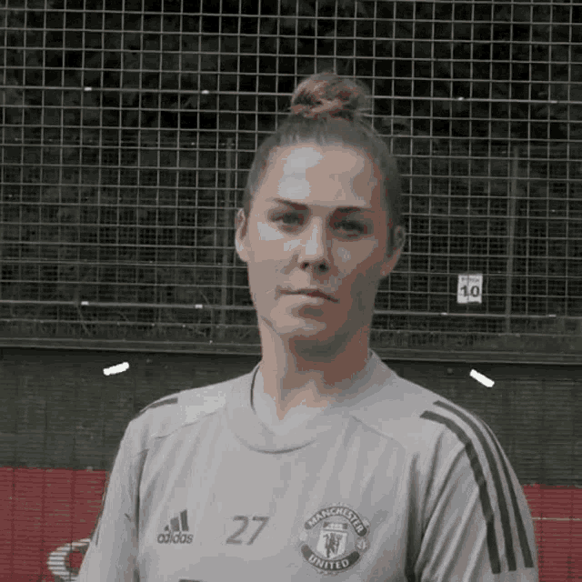 a woman wearing a manchester united jersey
