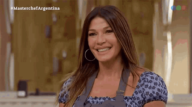 a woman is smiling in front of a screen that says masterchefargentina