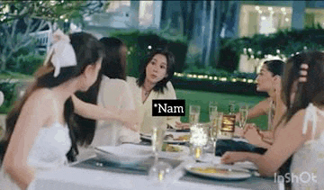 a group of women are sitting at a table with plates of food and wine glasses .