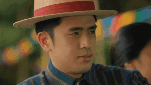 a man wearing a straw hat with a red band