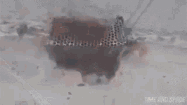 a car is driving down a snowy street in a blurry photo .