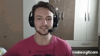 a young man wearing headphones and a microphone is smiling while looking at the camera .