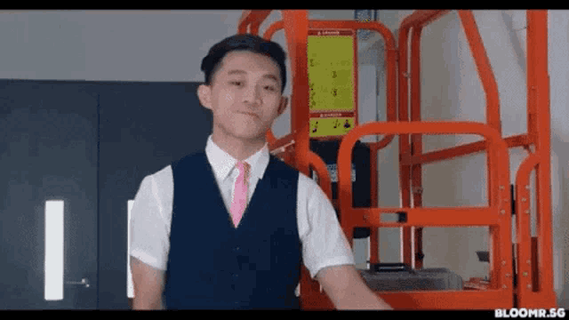 a man in a suit and tie is standing in front of a lift .