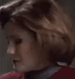 a close up of a woman 's face with a red sweater on .