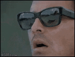 a man wearing sunglasses is holding a lighter in his mouth