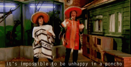 a man in a sombrero and a woman in a poncho are dancing in a room