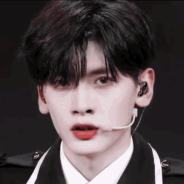 a close up of a person wearing a microphone with red lips