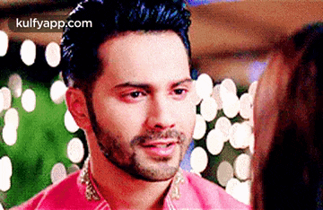 a man with a beard is looking at a woman in a pink dress .