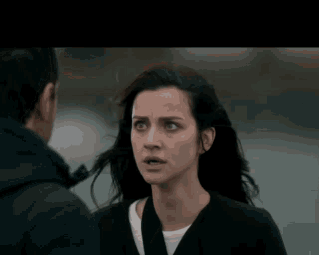 a man and a woman are looking at each other and the woman is making a sad face