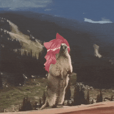 a squirrel with pink hair is standing on its hind legs in front of a mountain range