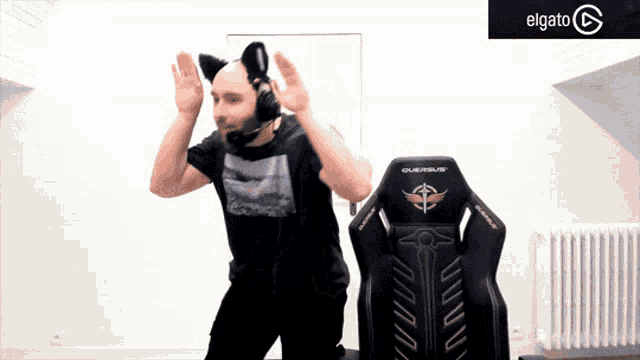 a man wearing a cat ear headset is dancing in front of an elgato logo