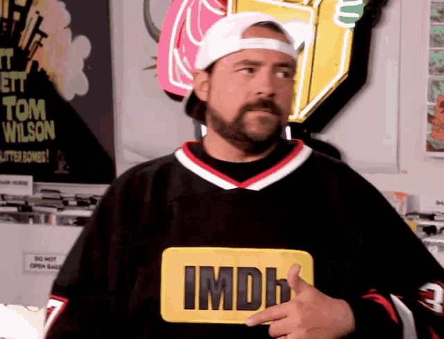 a man with a beard is wearing a imdb shirt