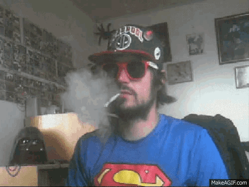 a man smoking a cigarette wearing a superman shirt