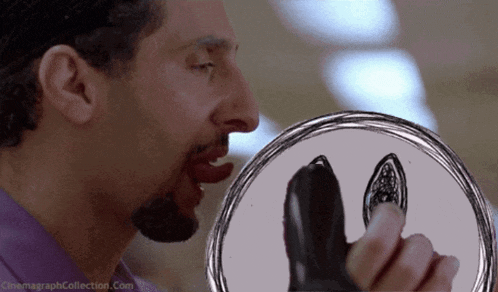 a man is holding a plate with a drawing of a shark on it and the website cinemagraphcollection.com is visible