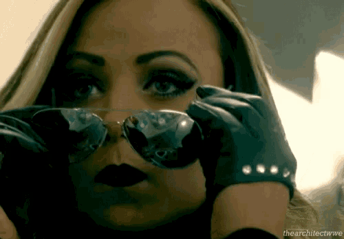 a close up of a woman wearing sunglasses and gloves with the words the architect wwe at the bottom