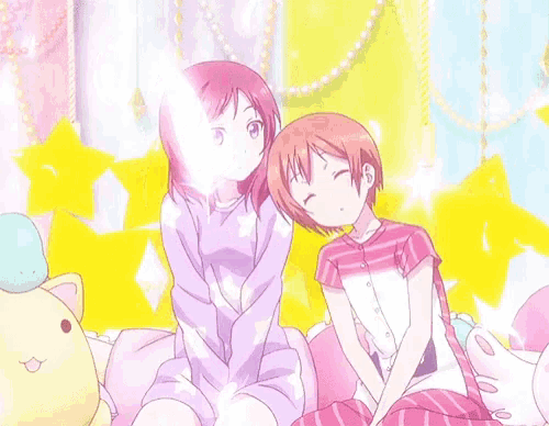 two anime girls are sitting next to each other on a couch