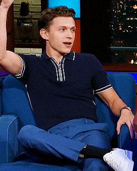a man in a blue shirt is sitting on a blue couch
