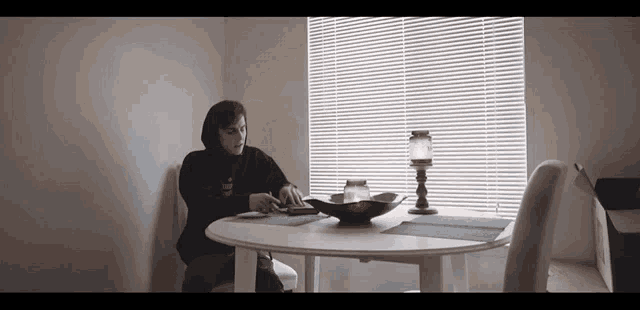 a person sitting at a table with a candle in front of them