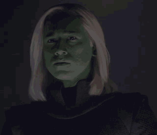 a woman with blonde hair and green face paint