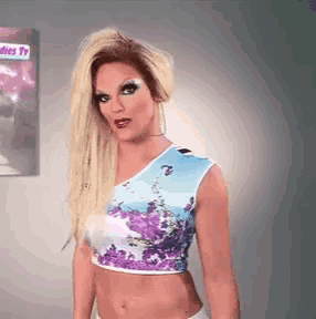 a woman in a floral crop top stands in front of a ladies tv sign