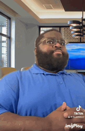 a man with a beard wearing glasses and a blue shirt has a tiktok icon above his face