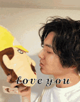 a man is kissing a stuffed animal with the words love you on the bottom