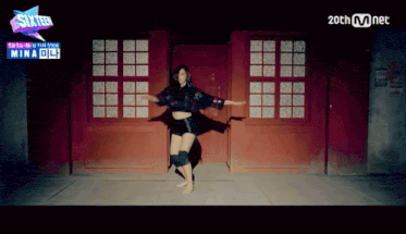 a woman is dancing in front of a red door with a sign that says sixteen