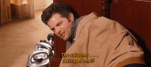 a man laying on a bed with the words the calzones betrayed me