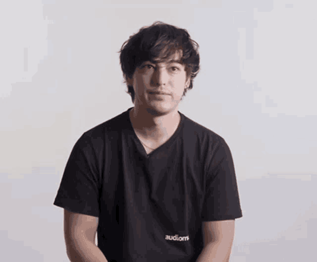 a man wearing a black t-shirt that says audiom