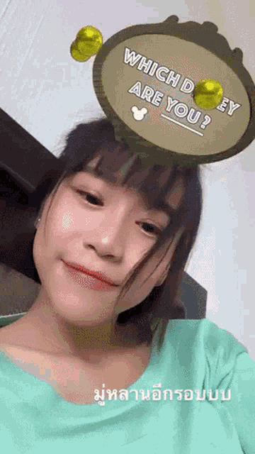 a woman wearing a green shirt has a sign on her head that says which d ey are you
