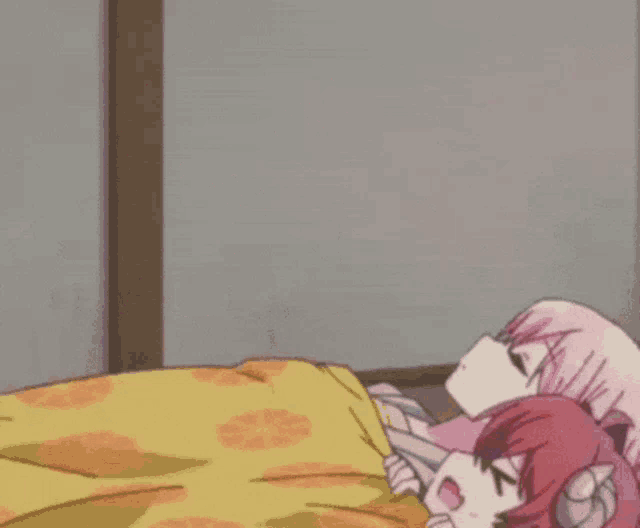 a girl with red hair is sitting next to a girl with pink hair laying on a bed .