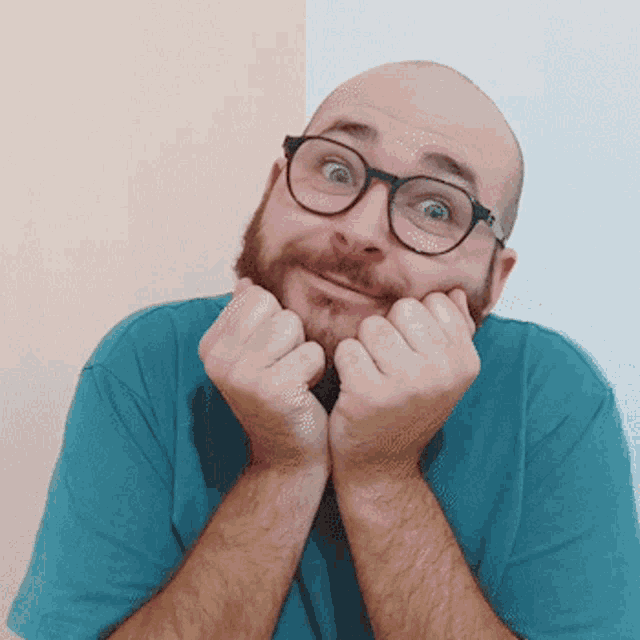 a bald man with a beard wearing glasses and a blue shirt
