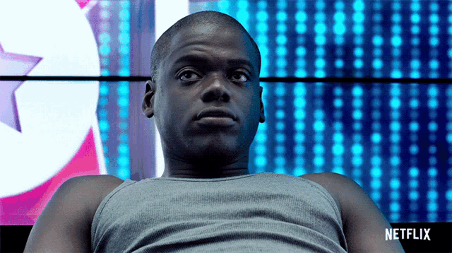 a man is sitting in front of a netflix sign