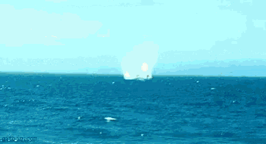 a boat is floating on top of a large body of water in the ocean .