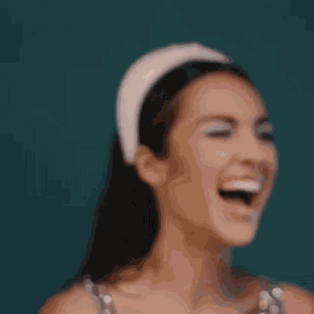 a close up of a woman wearing a white headband smiling