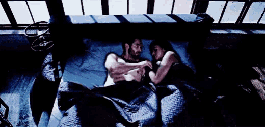 a man and a woman are laying in a bed .