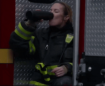 a close up of a fireman 's face wearing a helmet in front of a fire truck .