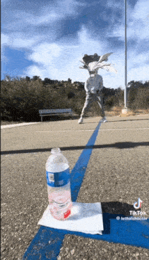 a bottle of water and a napkin are on the ground in a parking lot