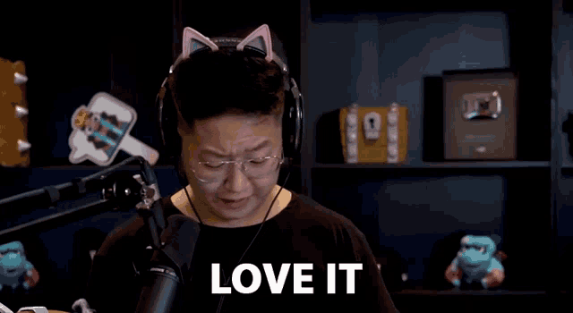 a man wearing headphones and cat ears is standing in front of a microphone .