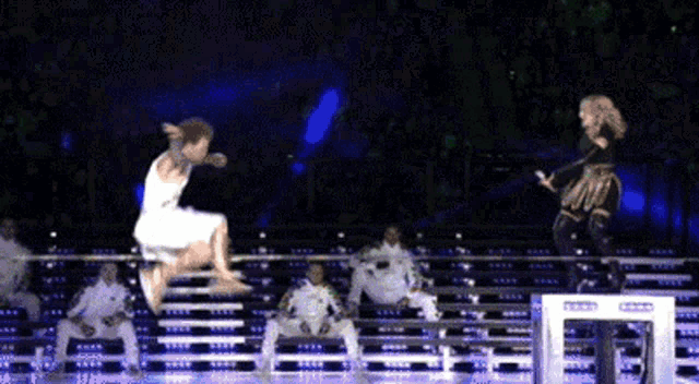 a woman in a white dress is jumping in the air while another woman stands behind her